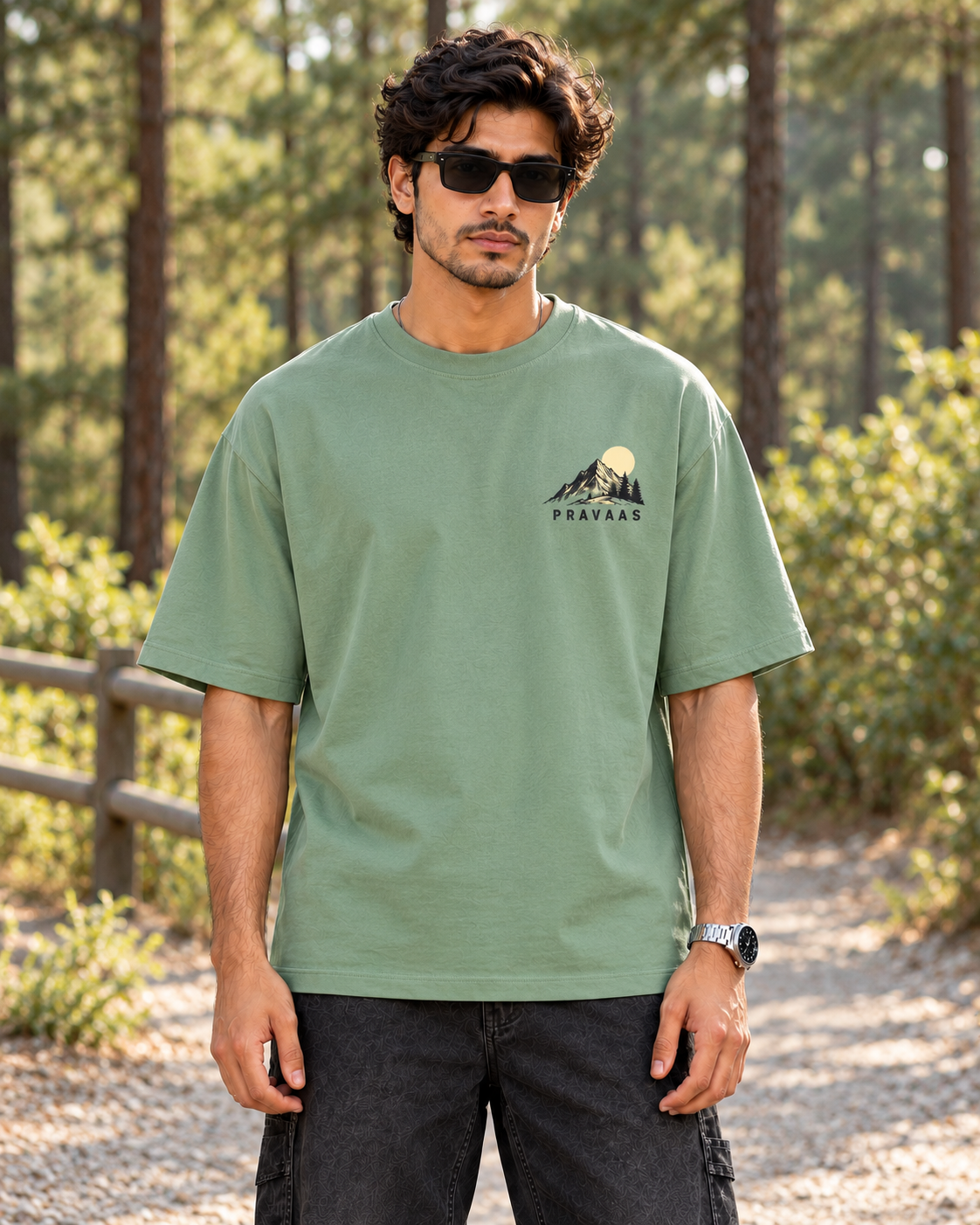 Pravaas Sage Green oversized T-shirt, male model front view on a pine forest trail