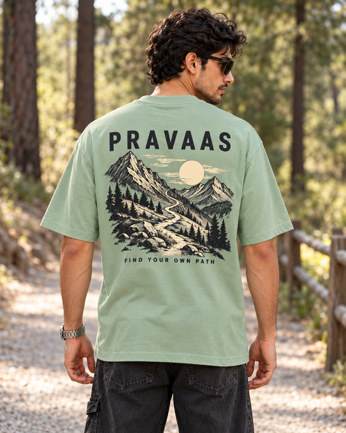 Pravaas Sage Green oversized T-shirt, male model back view on a pine forest trail